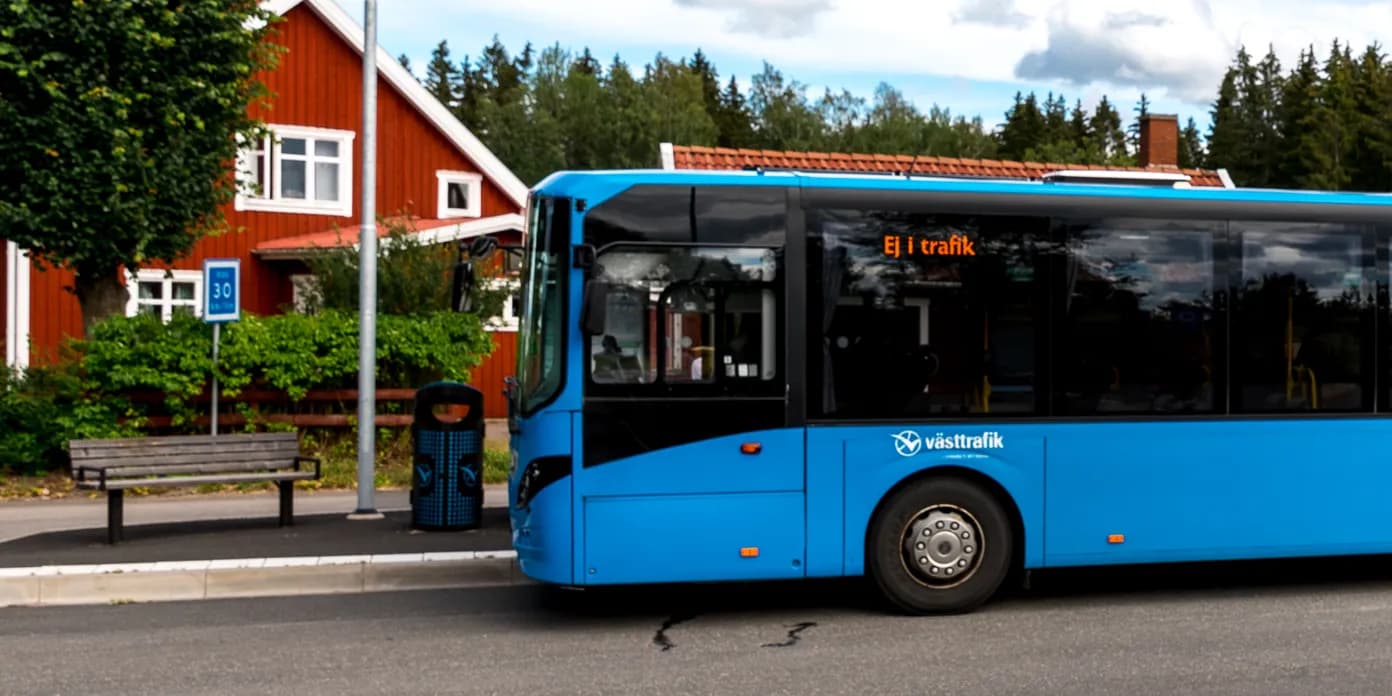 En blå buss parkerad på en parkeringsplats