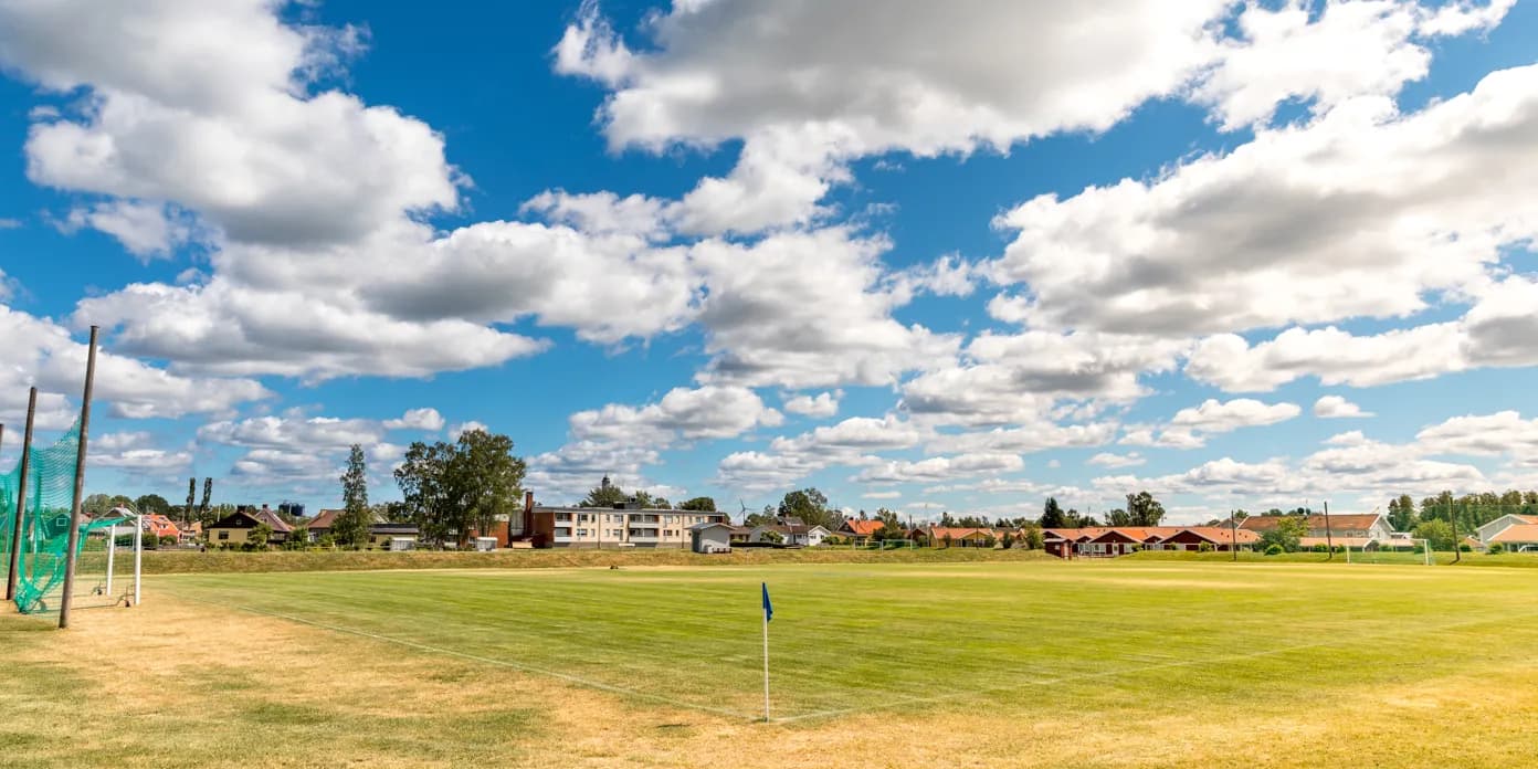 En fotbollsplan med blå himmel och vita moln