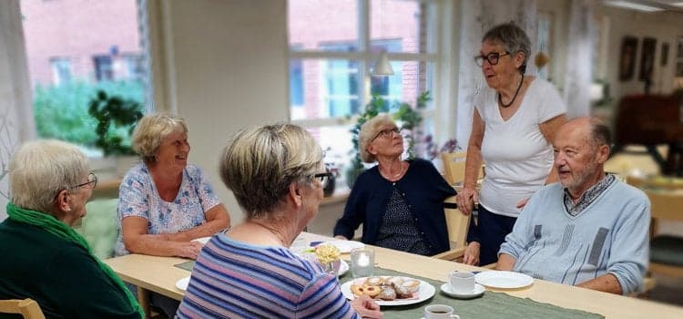 En grupp äldre människor som sitter runt ett bord