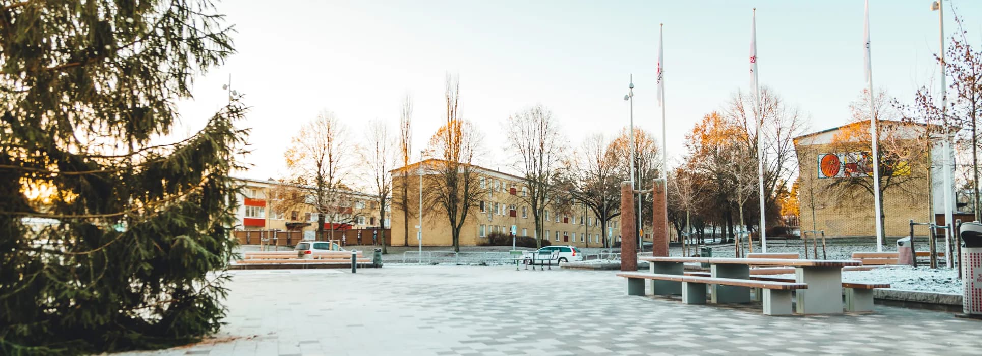 En park med bänkar och flaggor i bakgrunden