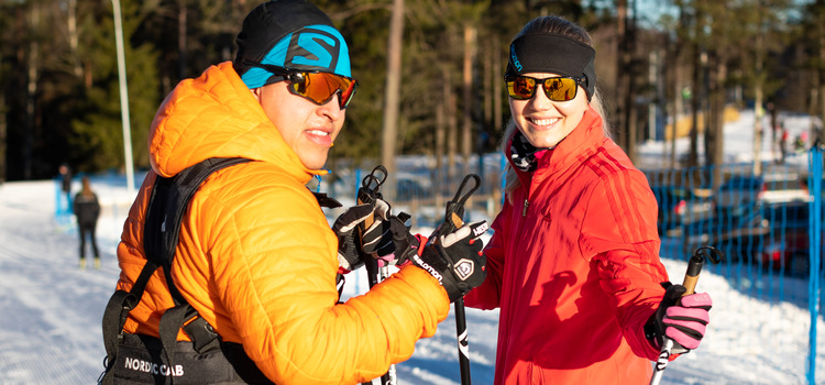 Picture of a man and a woman wearing ski clothes. He has a yellow jacket and she has a red jacket.