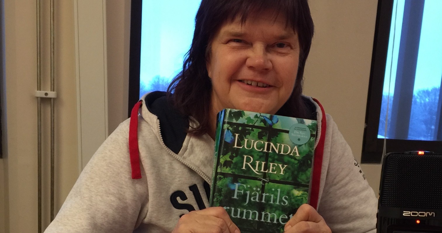 Yvonne håller upp boken Fjärilsrummet av Lucinda Riley